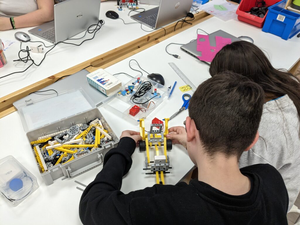 Niño y niña montando un robot a través de pìezas tipo LEGO