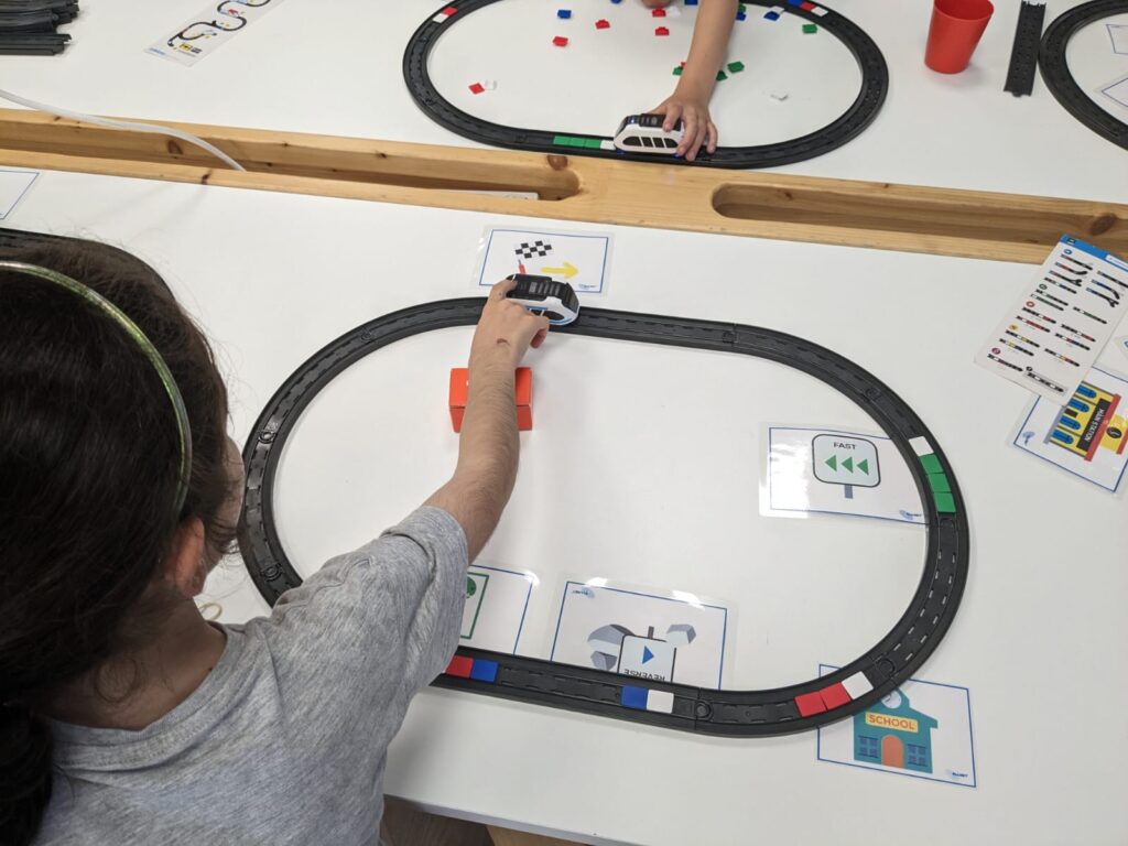 Niña programando el Intelino con fichas de colores.